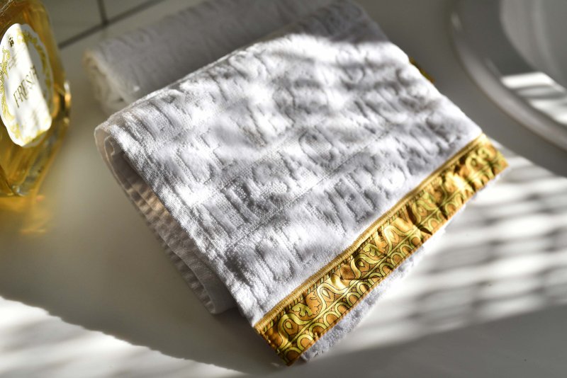 Weißes Handtuch mit goldener Bestickung
