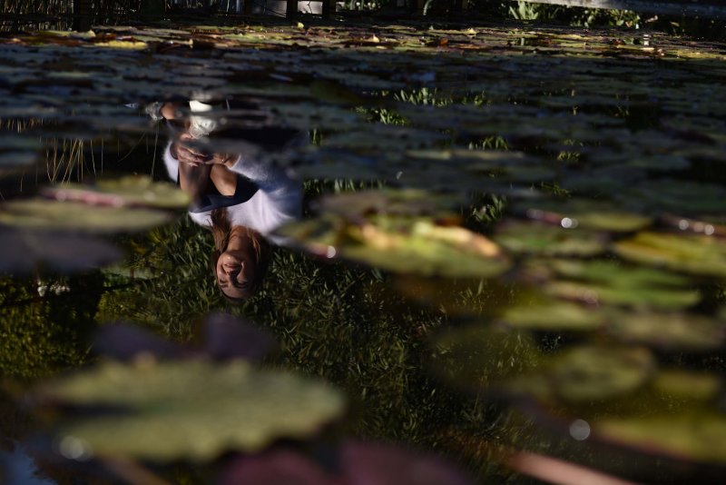Dettaglio di Coach Giselle seduta sul pontile, con il suo riflesso nell'acqua