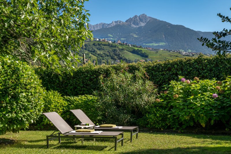 Liegestühle unter blauem Himmel und Berge.