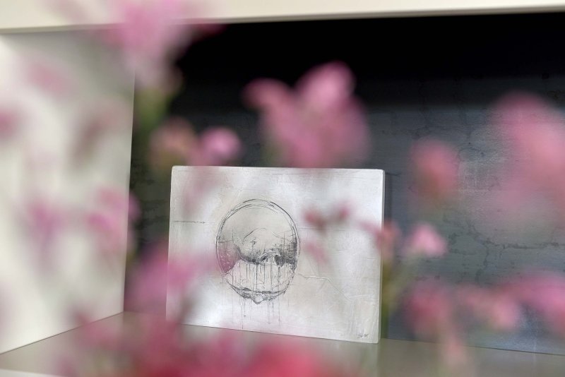 Rosa Blumen leicht verschwommen im Vordergrund, dahinter ein weißer Briefumschlag