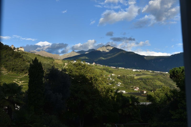 Hügelige Berglandschaft mit blauem Himmel und grünen Wiesen