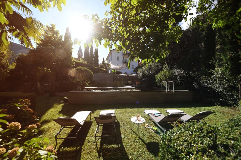 Vista sul giardino verde, in primo piano ci sono lettini