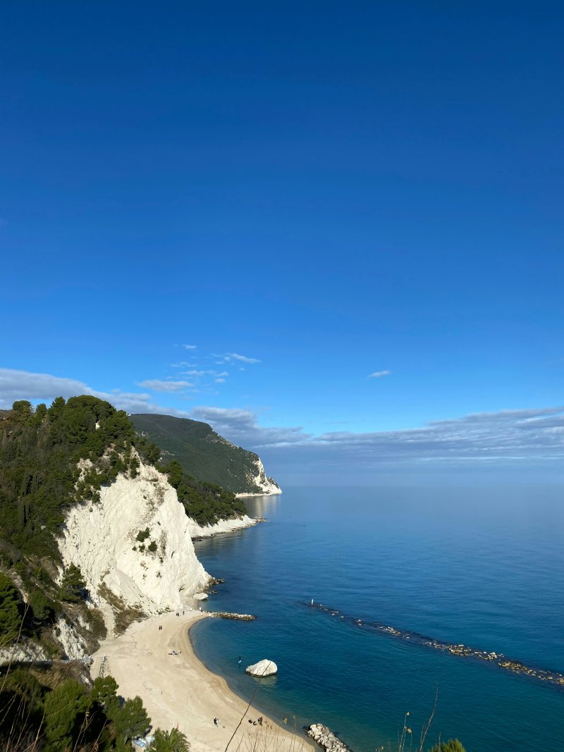Kristallblaues Meer, weißer Strand und Kalkfelsen unter blauem Himmel