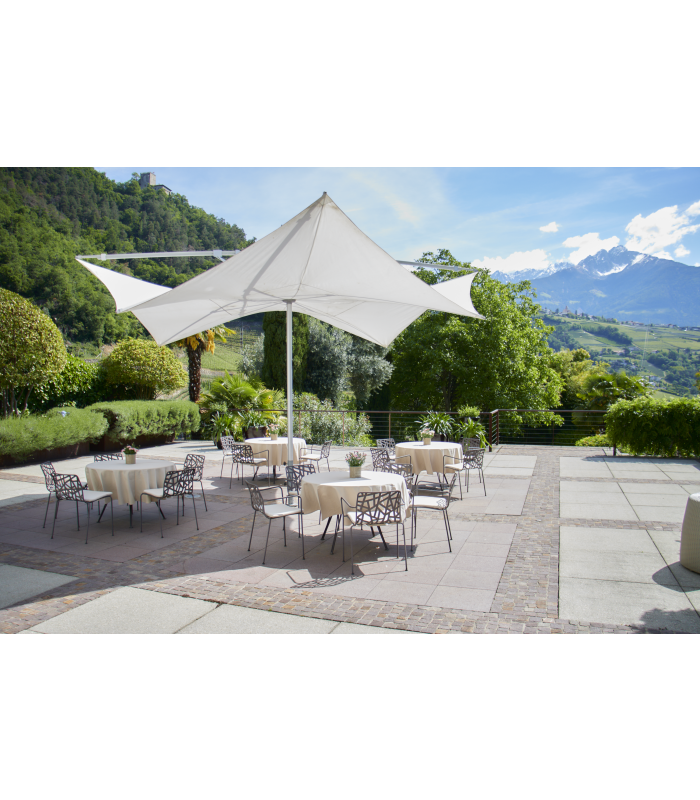 Terrasse mit Tischen Sonnenschirm und Stühlen und blauer Himmel