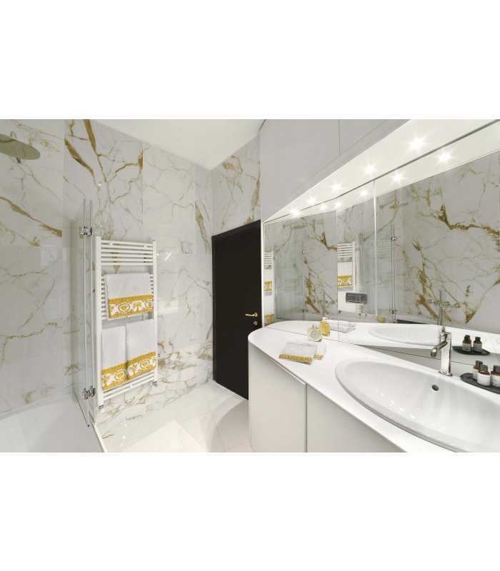 Bagno bianco luminoso con pareti marmorizzate d'oro