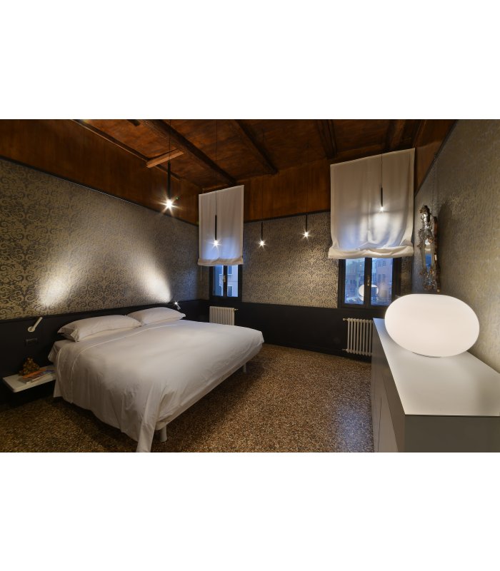 Ein Zimmer mit Doppelbett, dämmrigem Licht und Holzdecke im Refugium Amoris