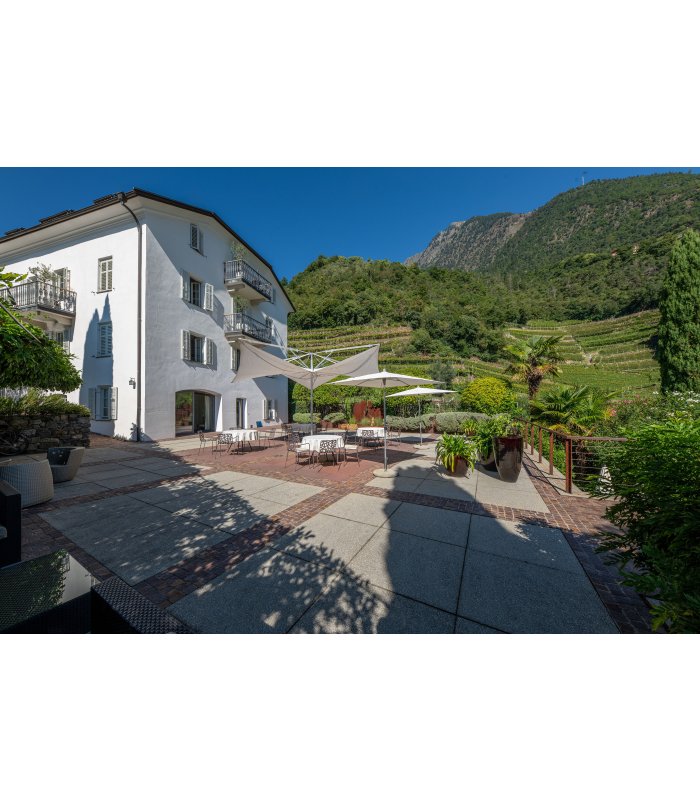 Terrasse mit Gartenmöbeln in Algund an einem Sommertag.