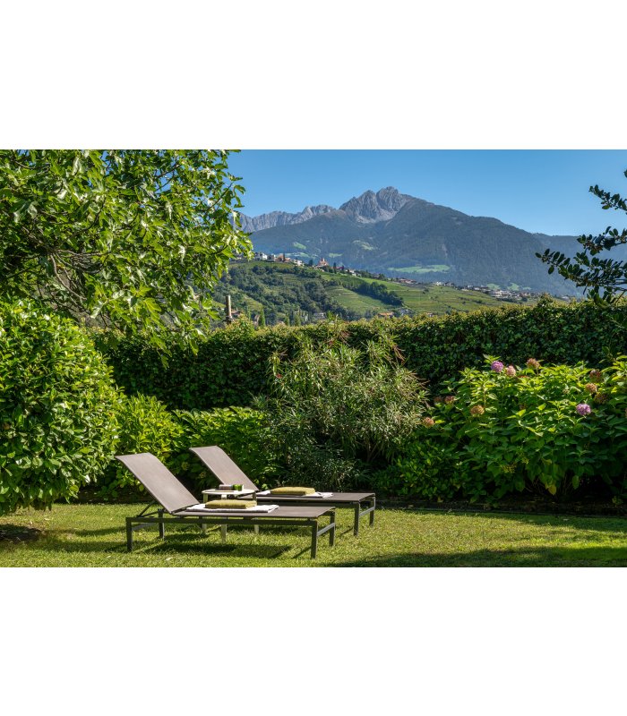 Liegestühle unter blauem Himmel und Berge.