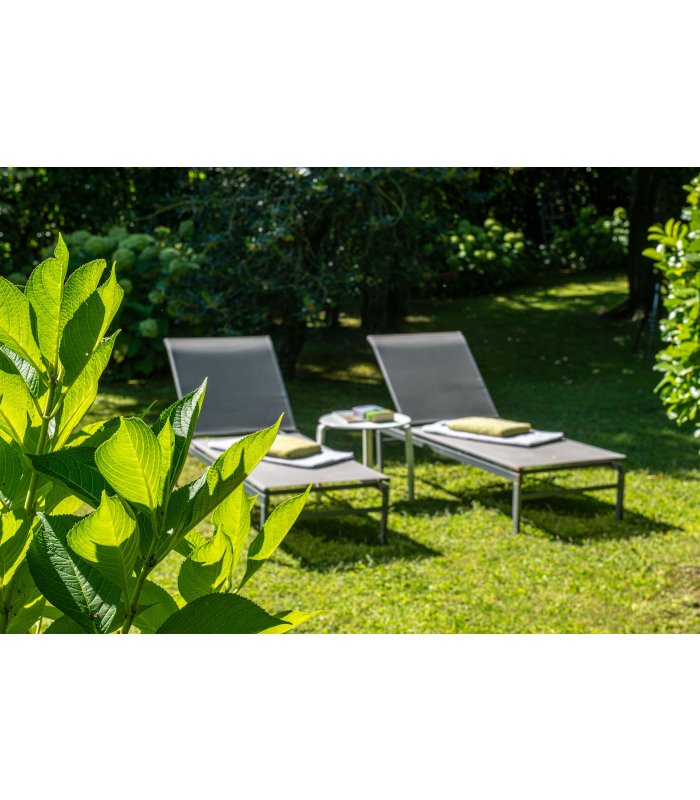 Grüne Liegestühle im Garten.