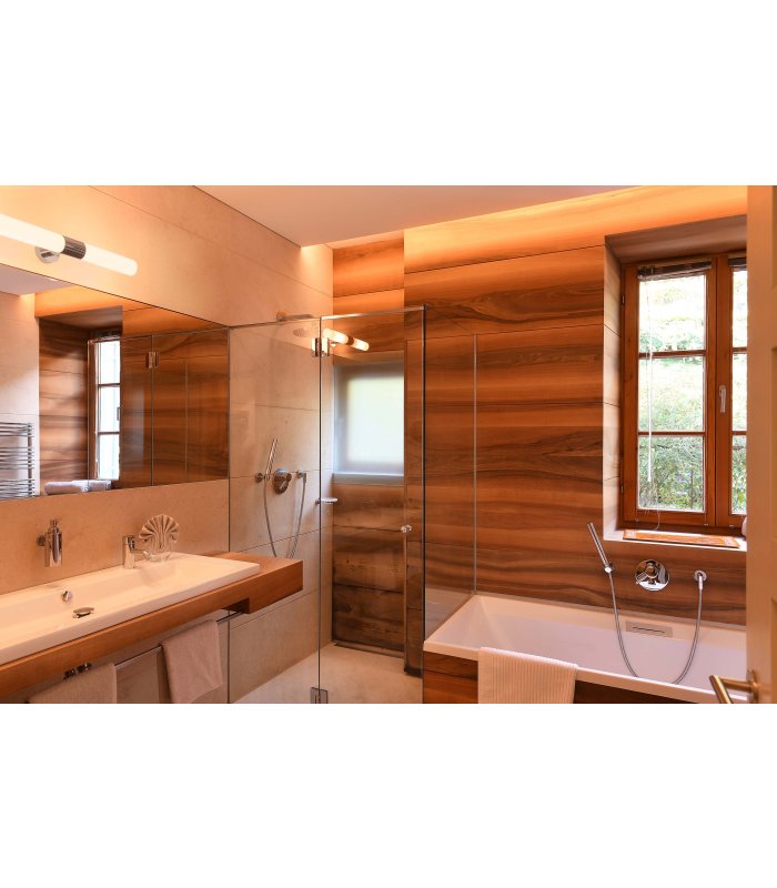 Helles Badezimmer mit Holzwandoptik, Badewanne und großem Waschbecken