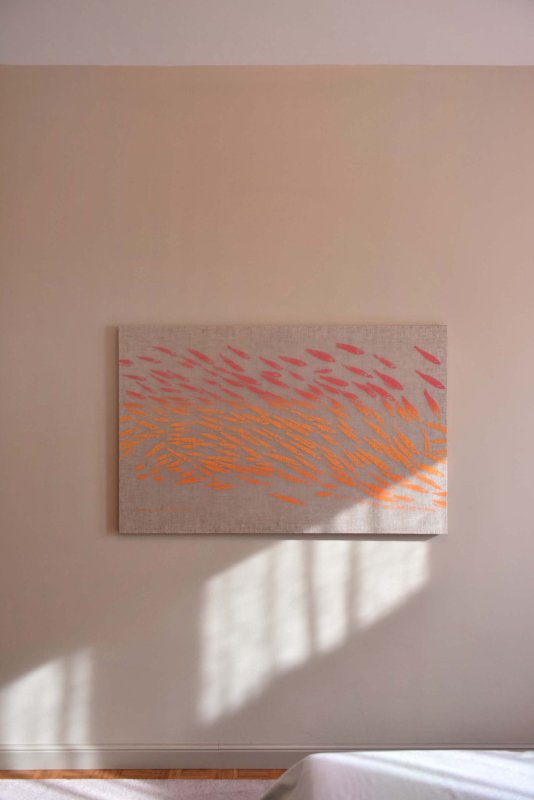 Schlichtes Kunstbild mit orangenem Druck an der Wand