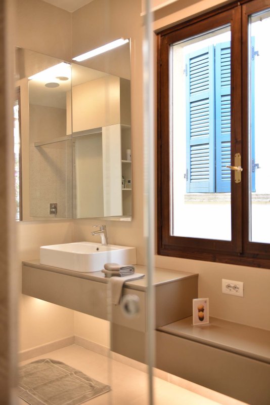 Badezimmer mit Waschbecken, Spiegel und barrierefreier Dusche