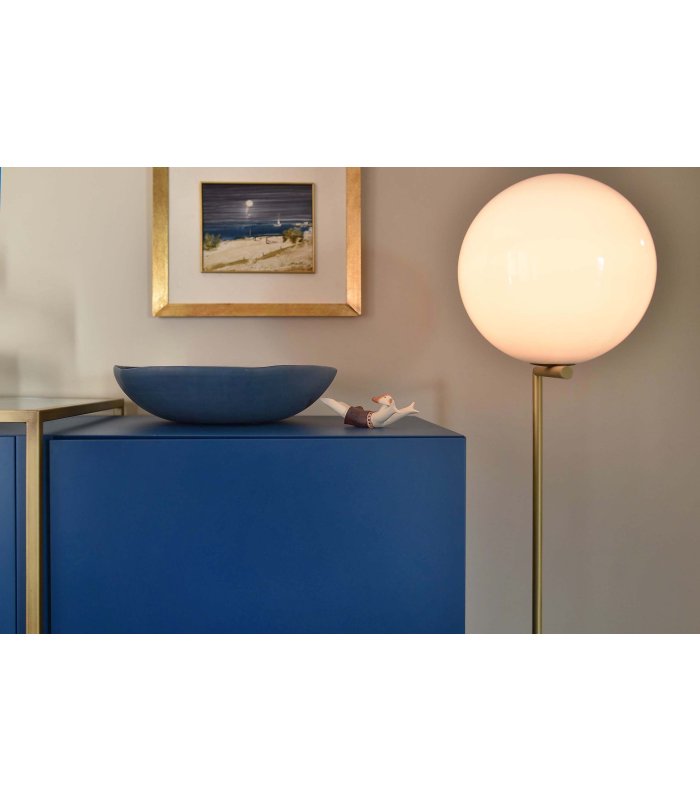 Kleines Männchen und große blaue Schüssel als Dekoration auf blauem Regal