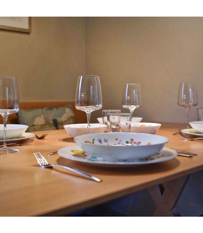 Nahaufnahme von schön angerichtetem Geschirr und Weingläsern auf Holztisch