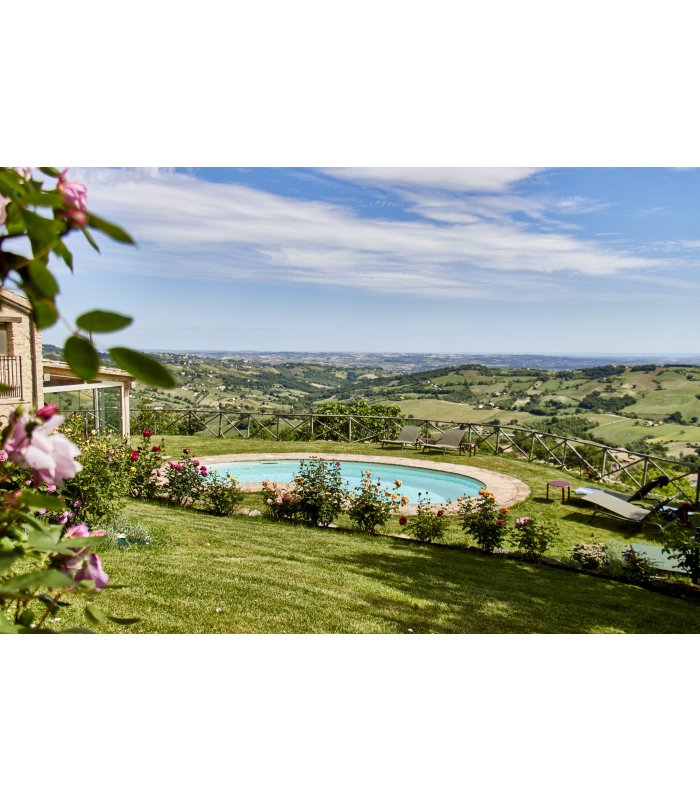 Round pool overlooking a vast hilly landscape under a blue sky
