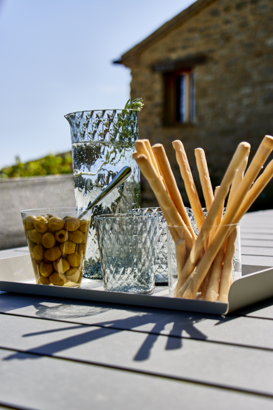 Knabberstangen und Oliven auf einem hellen Tisch vor dem Haus