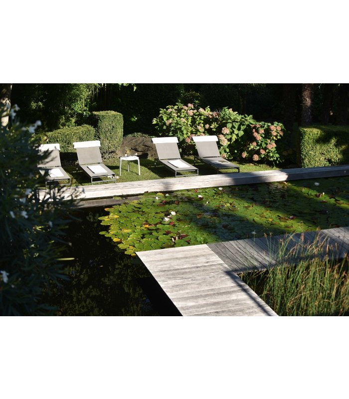 Sonnenliegen und ein Teich im sonnigen Garten