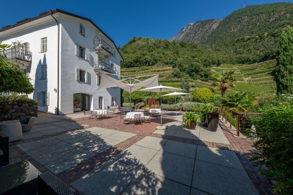 Terrasse mit Gartenmöbeln in Algund an einem Sommertag.