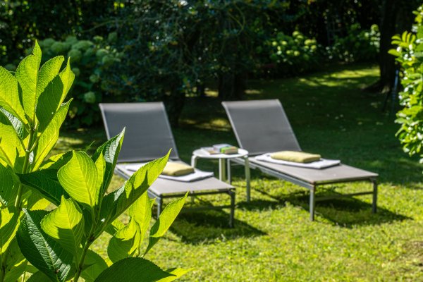 Grüne Liegestühle im Garten.
