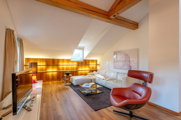 Wohnzimmer mit großer Couch und Ledersessel