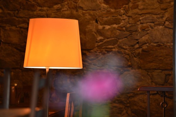 Orange kleine Lampe vor brauner Wand