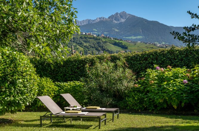 Liegestühle unter blauem Himmel und Berge.