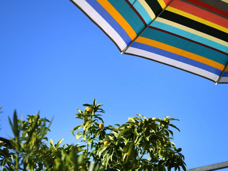 Blick auf den blauen Himmel unter dem Sonnenschirm