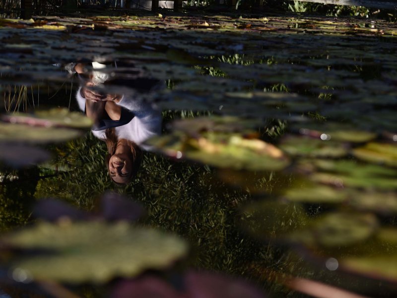 Close-up of Coach Giselle sitting on the dock, with her reflection in the water