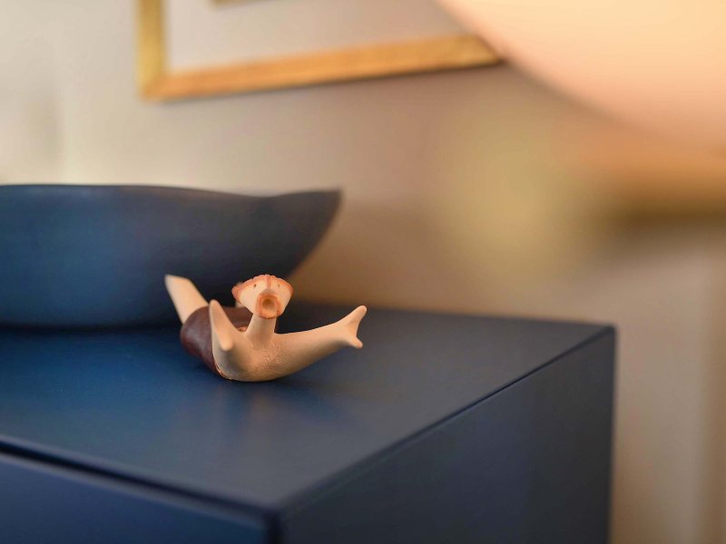 Piccolo pupazzo come decorazione su una mensola blu