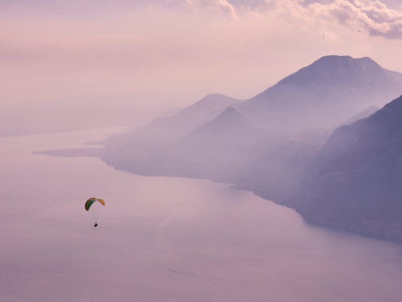 Paraglider schwebt über dem idyllischen Gardasee